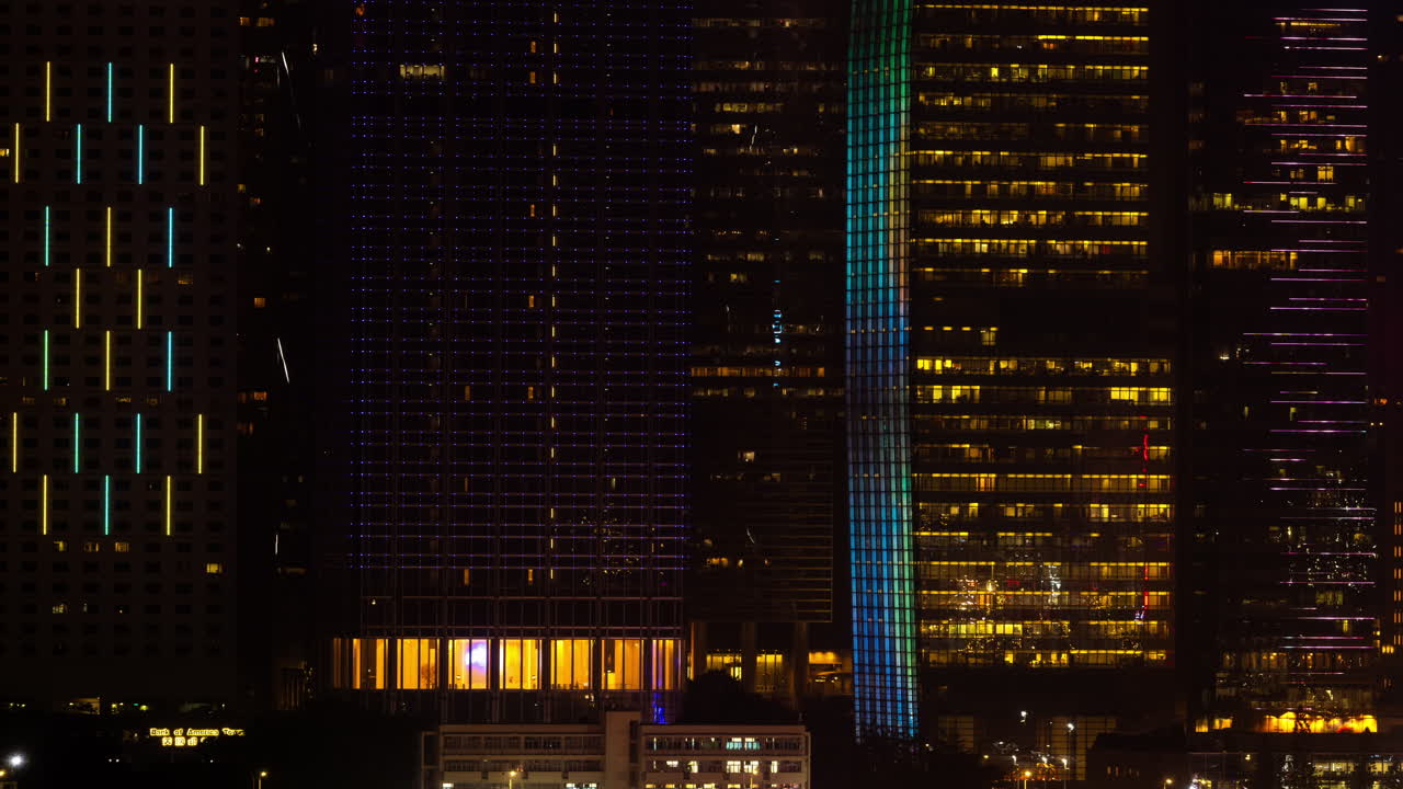 HONG KONG - 19 MARCH 2025 : Hong Kong Central city skyline filmed from across the harbour in kowloon with all the skyscrapers lit up at night advertisements
