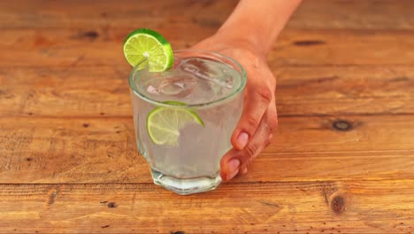 close-up of a gin and tonic cocktail on a wooden table in a restaurant