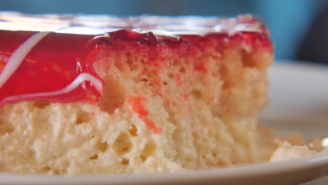 slice of tres leches cake with red jelly topping