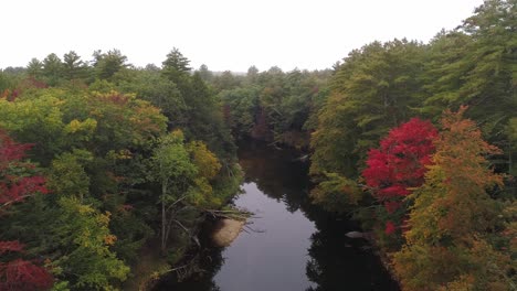 Nebeliger-Fluss-Aus-Der-Luft-Mit-Herbstlaub-Ziehen-Sich-Zurück-Und-Steigen-Mit-Dem-Vorbeifahrenden-Auto-Auf-Der-Straße