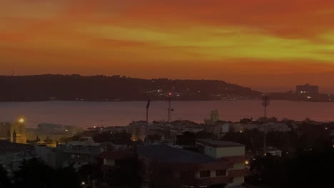 aerial view of caparica from lisbon over river tagus in orange silhouette sky