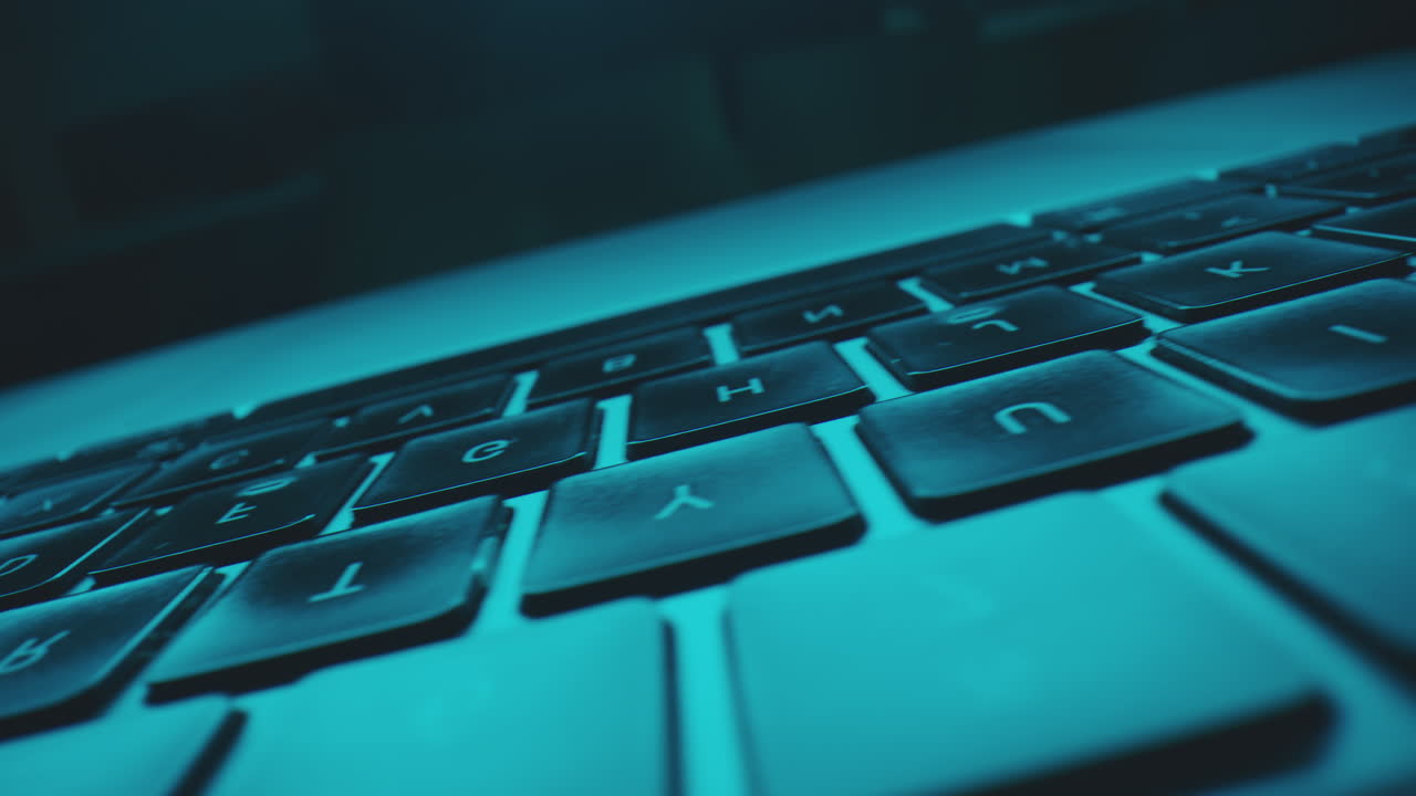 Close-up of a Laptop Keyboard Under Blue Light
