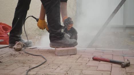man using a hand held circular saw with a masonary cutting blade to cut paving stones