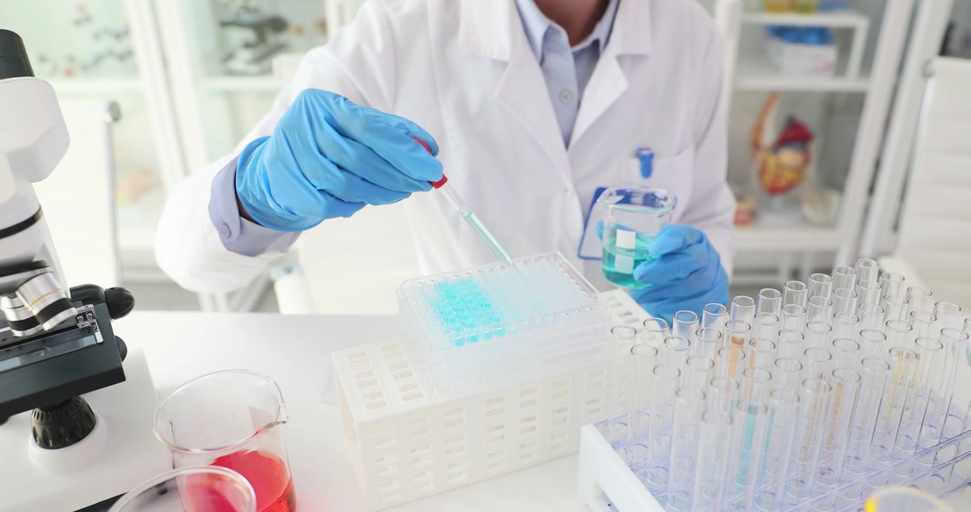 Teknisyen, pipet ve test tüpleri kullanarak numuneleri analiz ediyor