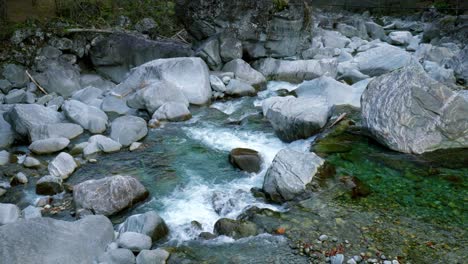 Disparo-De-Un-Drone-Con-Pedestal-Moviéndose-Desde-Abajo-Hacia-Arriba,-Sobre-El-Río-Maggia,-Situado-En-El-Pueblo-De-Cavergno,-En-El-Distrito-De-Vallemaggia,-Cantón-De-Ticino,-En-Suiza