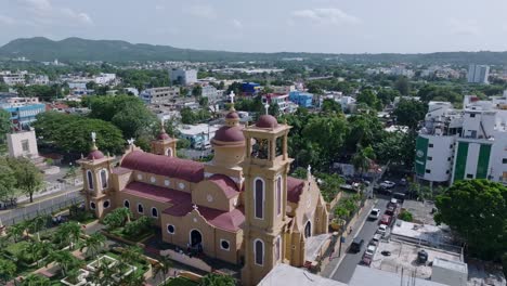 Toma-Aérea-Ascendente-De-La-Catedral-Amarilla-Con-Techo-Rojo-En-La-Ciudad-De-San-Cristóbal-Durante-El-Día-Soleado---Vuelo-Hacia-Atrás