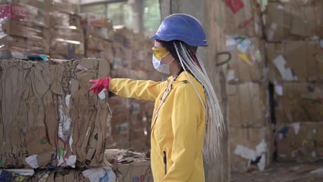 Unloading-Of-Waste-Paper-In-A-Warehouse-Electric-Car-Controling-By-Female-Worker-In-Hard-Hat-And-Yellow-Jacket