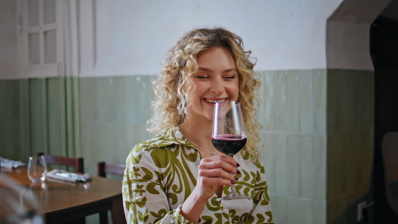 Smiling women enjoying wine glass in relaxed restaurant closeup. Blonde toasting