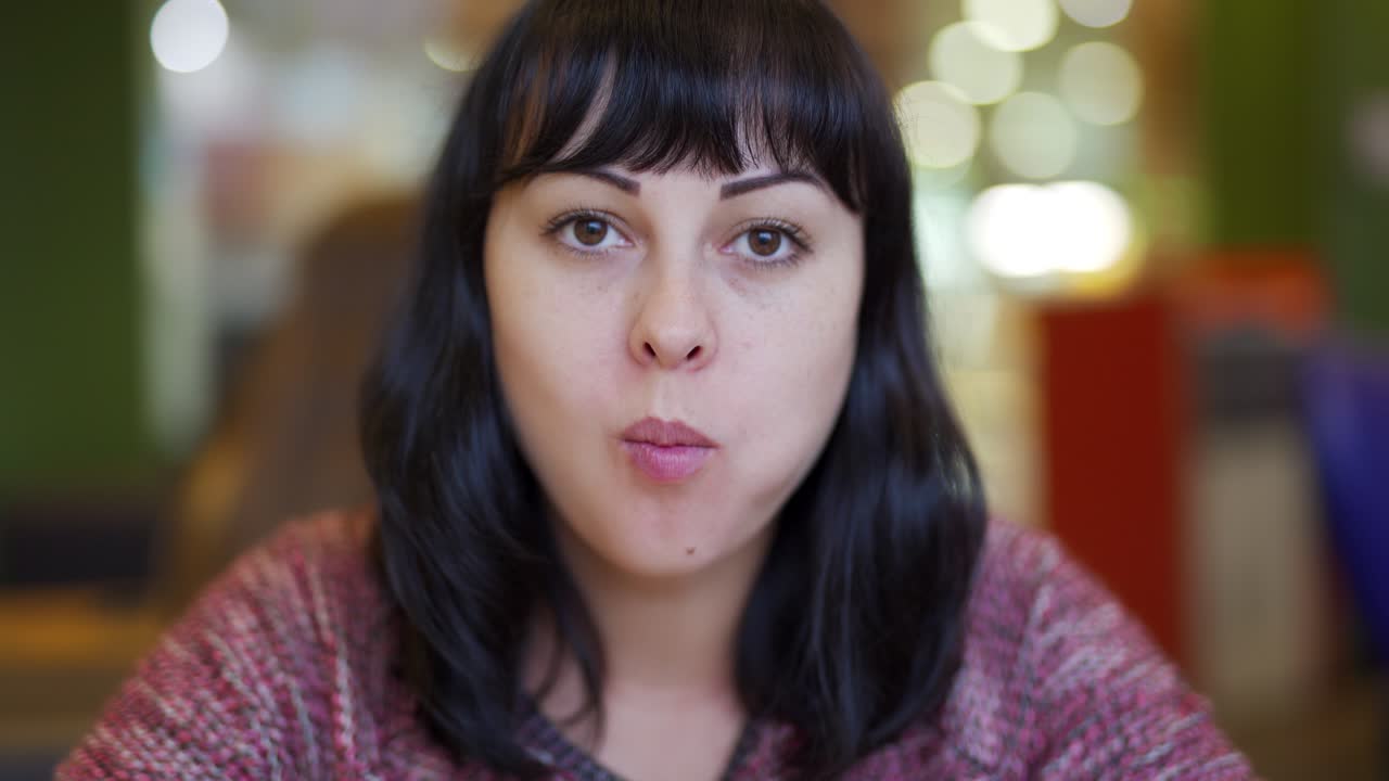 hungry young woman eating a big hamburger in a fast food restaurant