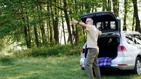 Caucasian male speaks on the phone in nature. Happy person working remote. Rest in the forest.