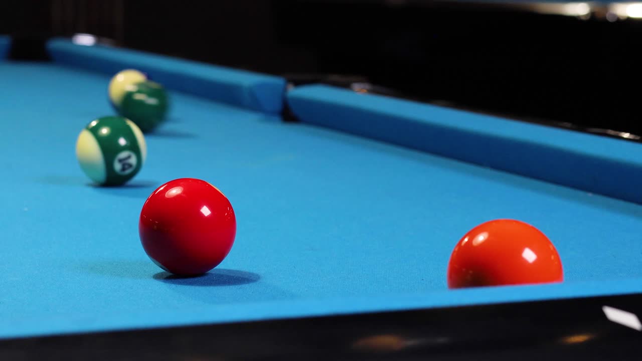 Playing a game of billiards pool hitting green ball with cue ball
