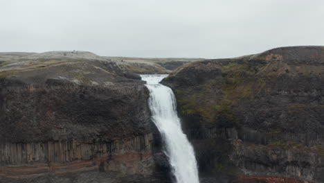 Drone-Orbitando-Alrededor-Del-Salto-De-La-Famosa-Cascada-De-Haifoss-En-El-Sur-De-Islandia.-Vista-Aérea-De-La-Espectacular-Y-Famosa-Cascada-De-Haifoss.-Belleza-En-La-Tierra.-Cascada-De-Haifoss