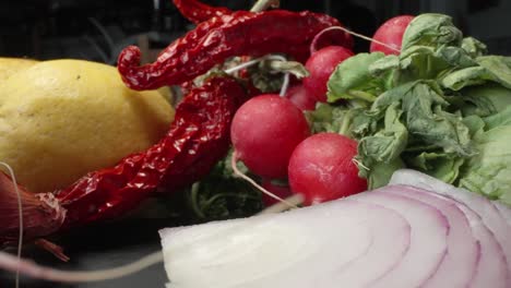 a close-up shot captures a chef carefully cutting a black radish on a black slate cutting board