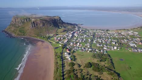 Stunning-aerial-flight-over-Stanley-towards-a-huge-rock-in-Tasmania,-Australia