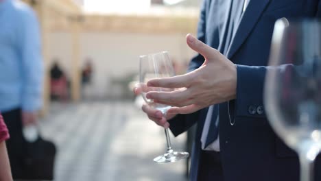 businessmen discussing business holding a glass of wine in hand