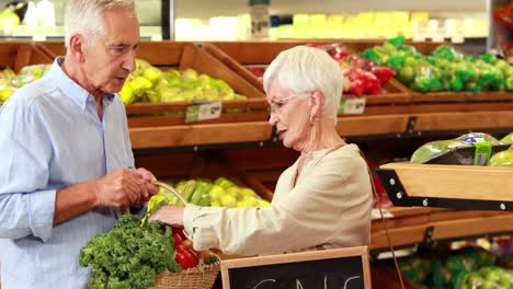 Senior-couple-picking-out-vegetables-in-supermarket