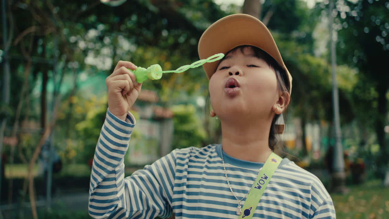 공원에서 거품을 불어넣는 소녀