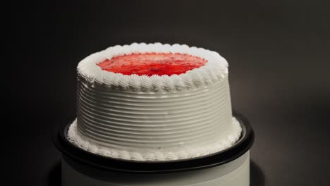 fresa bayas gelatina pastel con crema en una mesa giratoria con fondo negro bucle sabroso deleite dulce delicioso