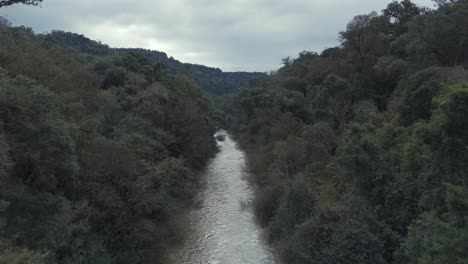 River-deep-in-the-rainforest-jungle-forest-nature,-aerial-over-tree-canopy