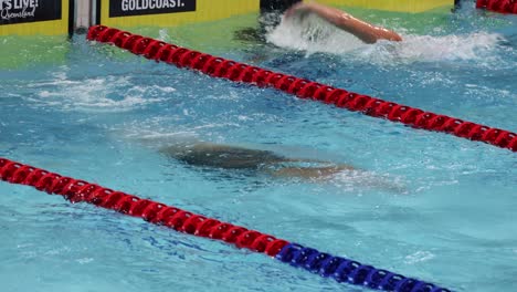 swimmer racing in pool, showcasing speed and skill