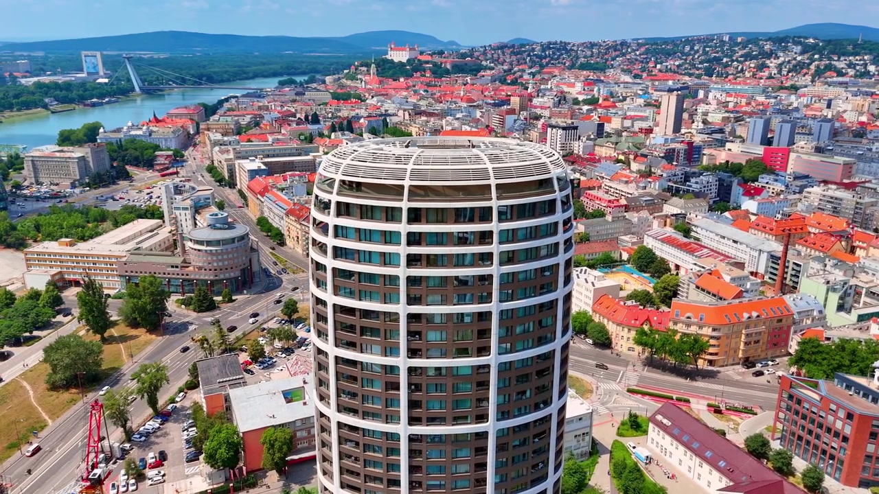 Paesaggio urbano con il Castello di Bratislava su una collina, Bratislava, Slovacchia. Prospettiva da drone che rivela i tetti rossi del centro storico e un moderno grattacielo residenziale in primo piano