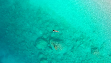 Top-Down-Antenne-Eines-Mädchens,-Das-Im-Paradiesischen-Türkisfarbenen-Ionischen-Meer-In-Griechenland-Myrtos-Beach-Schwimmt-Und-Liegt