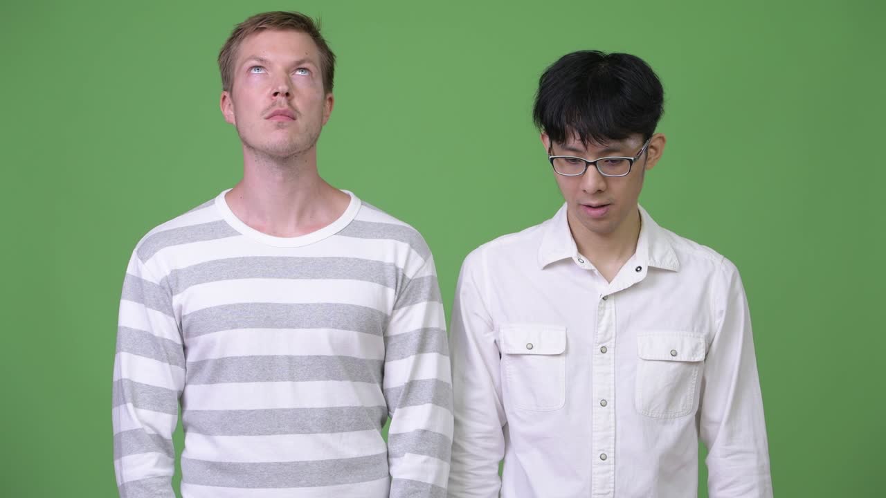 두 명의 젊은 다민족 사업가들이 서로 반대 방향을 바라보고 있습니다.