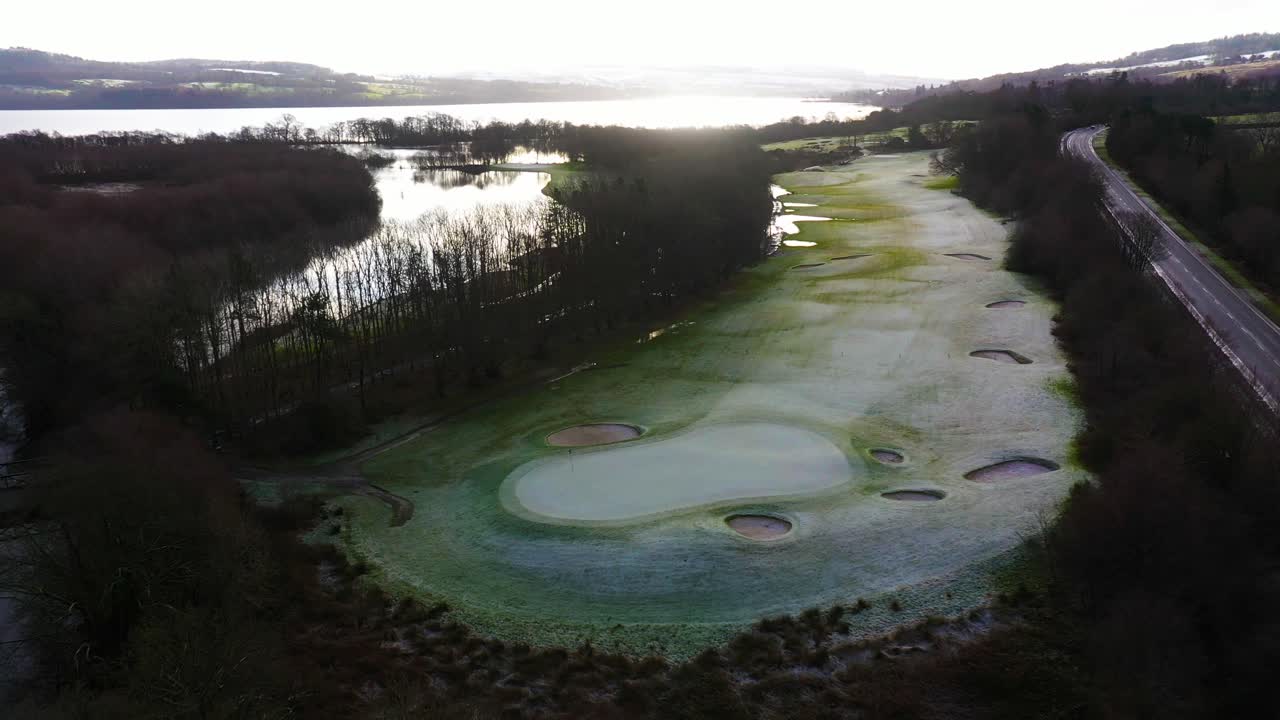 Aerial View of a Frozen Golf Course by a Lake at Sunrise