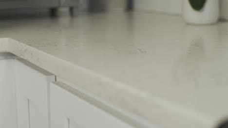 smooth rack focus on a white granite countertop in newly remodeled kitchen