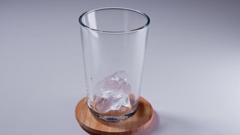 agregue hielo picado en un vaso con hielo triturado sobre una mesa