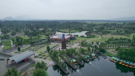 tomas orbitales sobre un lago con vista de trajineras, una carretera y un área natural en xochimilco ciudad de méxico