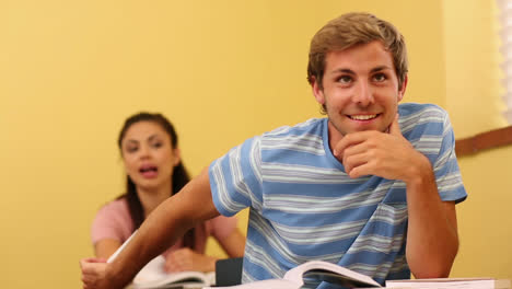 estudiante pasando una nota a su compañero de clase
