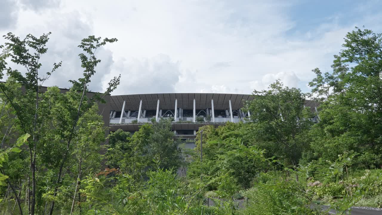 Tokyo's sports hub: views of the National Stadium facade, commemorative plaques on a long walkway, and "Gaiennishi-dori Ave." and "Tokyo Met. Gym." signs