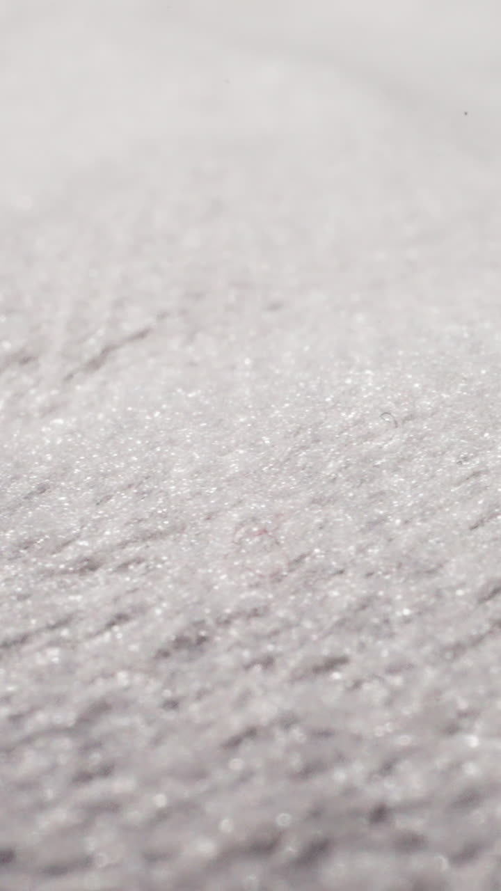 White fabric with glitter threads at bright light extreme close view. Textile material texture sheet. Shiny flat cotton cloth textured surface