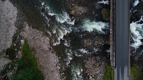 aerial bird's eye of car passing over låtefoss bridge at låtefossen waterfall