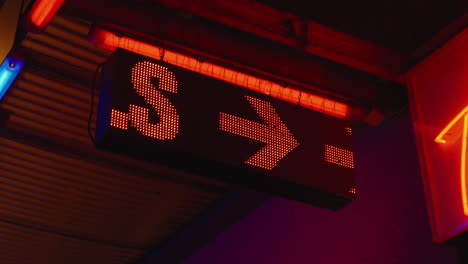 red led sign displaying the word girls with arrow outside strip club, close-up