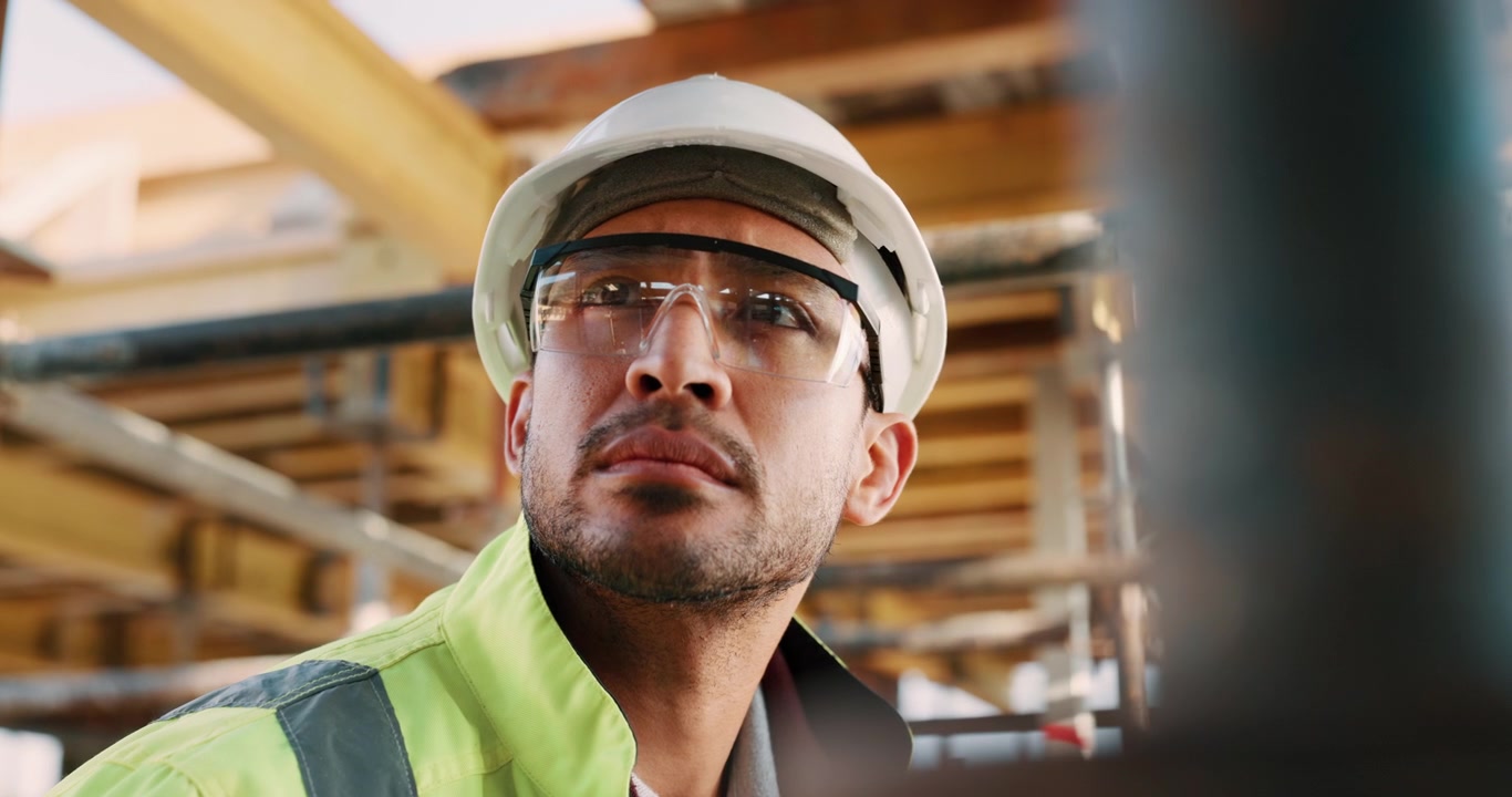 Construction Worker Wearing Safety Gear Looking Up at Site