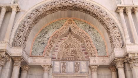intricate details of a venetian church facade with ornate stone carvings and marble arches in venice