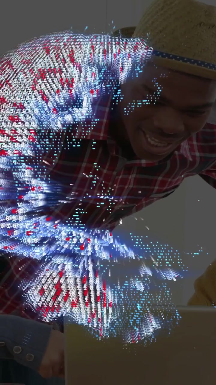 Vertical video: Man leaning over laptop and shaping 3D point-cloud with hands for tech demo