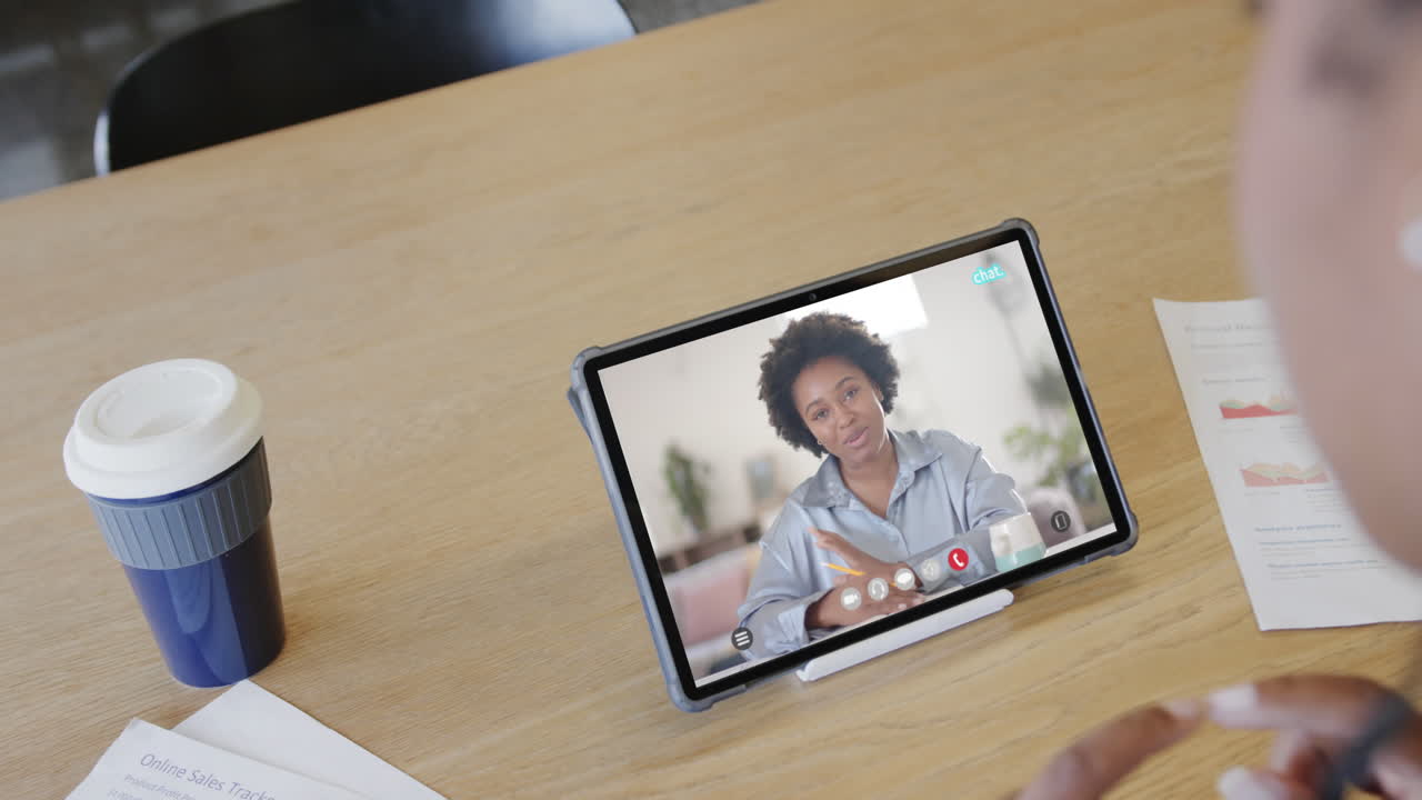 mujer de negocios caucásica en una videollamada con una colega afroamericana en la pantalla