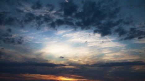 wide view of sky with dark blue and orange background clouds at sunset in 4k
