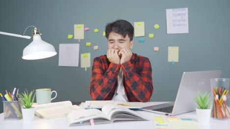 male student stressed and biting his nails.