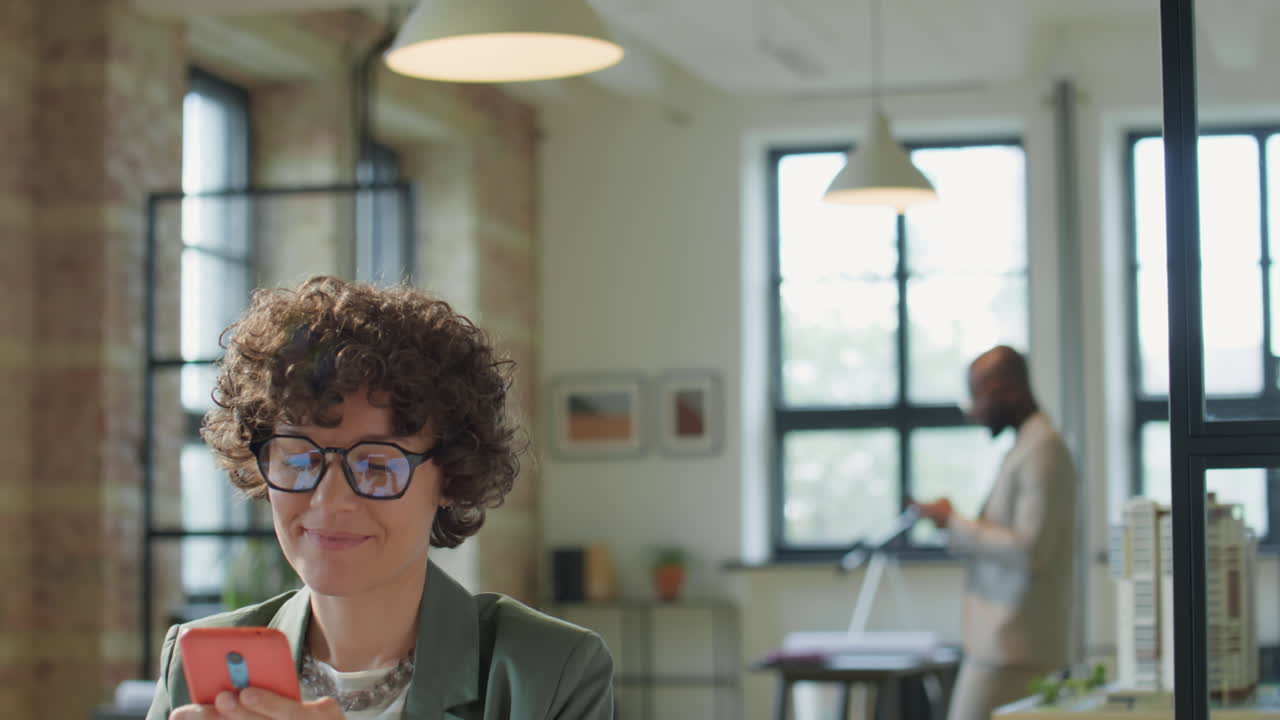 Donna che usa lo smartphone in un ufficio moderno