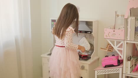 little girl playing in playroom in pretty dress