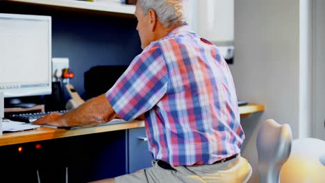 hombre mayor usando una computadora de escritorio en casa 4k
