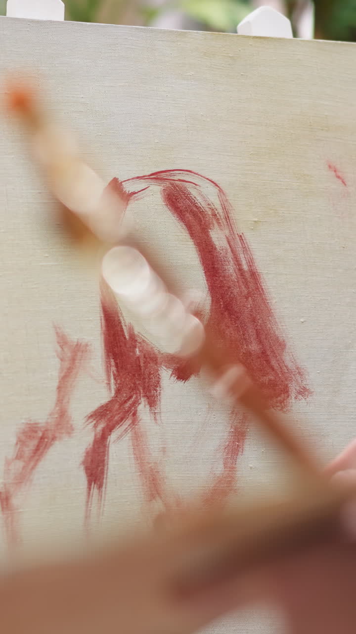 художник рисует портрет женщины в студии крупного плана. мужчина использует кисть, чтобы оставить цветные пятна на холсте в художественной мастерской. дизайнер работает с масляными красками