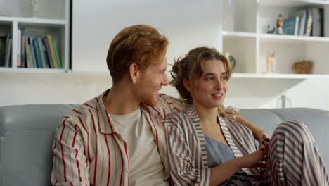 married people hugging couch in pajamas closeup. happy family morning leisure.