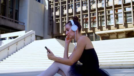 Female-ballet-dancer-listening-music-on-mobile-phone-4k