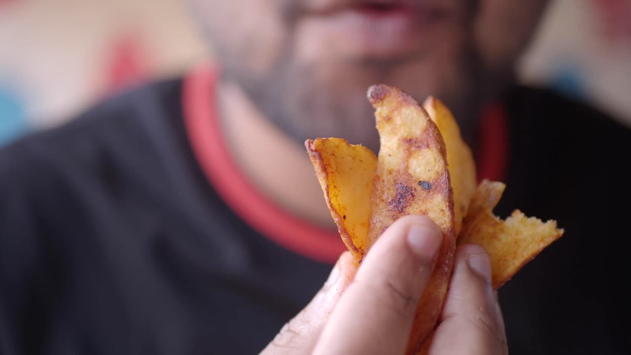 Close-up of a person holding potato wedges