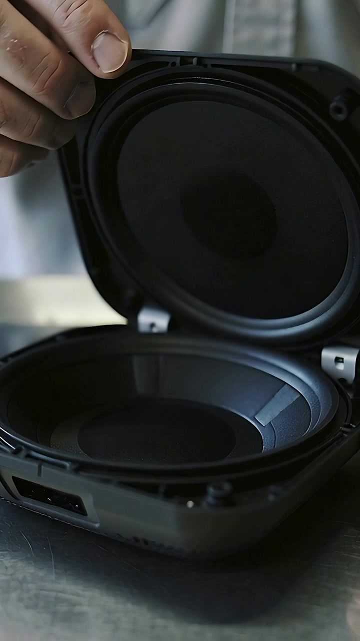 Vertical video: Pressing grille, man in light shirt lifting speaker lid on worktop, checking driver
